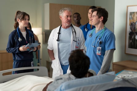 Four young doctors stand by a patient’s bed with Dr Perry Cox