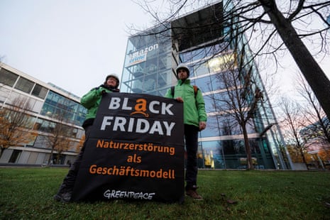 Activists of Greenpeace hold a banner reading 'Black Friday. Nature destruction as a business model' in front of the Amazon headquarters in Munich, Germany, today.