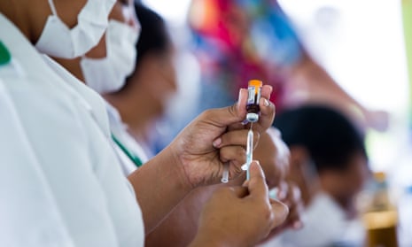Health worker prepares a vial of vaccine