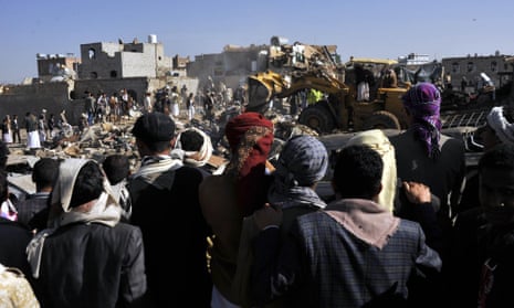 People gather at a bombed site in Sana'a after Saudi-led air strikes