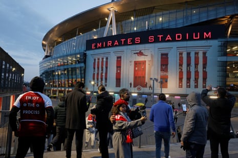 Some of the fans arriving for Arsenal's game against Manchester City take pictures of the new facade of the Emirates stadium that looks like the old front of Highbury.