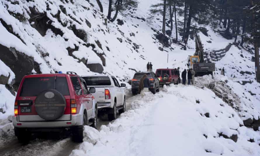 Vehicles wait for heavy machinery to clear a snow-choked road in Neelum Valley