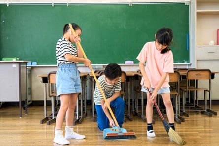 Japanese children clean their classroom after a lesson.