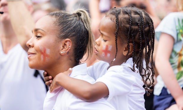 Two fans in Trafalgar Square with England flags painted on their faces