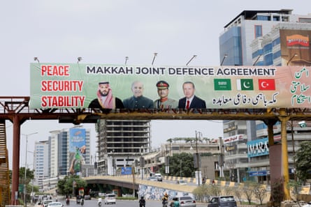 A billboard above a busy road in Karachi. The sign says ‘Peace, security, stability’ and ‘Makkah joint defence agreement’ and shows pictures of the Saudi crown prince, Pakistan’s prime minister, Gen Asim Munir and the Turkish president