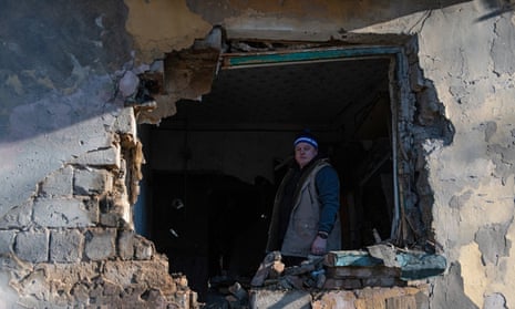 A man stands inside an apartment damaged by shelling in Donetsk.