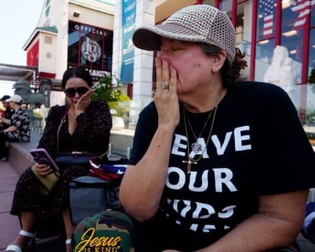 Deux femmes assises à l’extérieur se tenant la main sur la bouche.