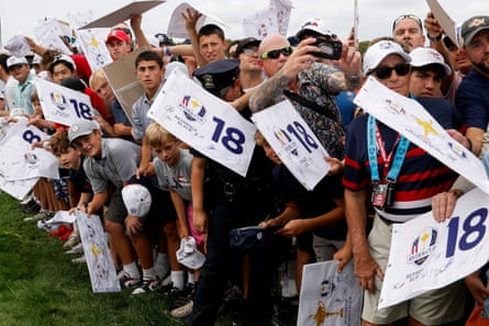Fans wave cards with signatures on them beside the course