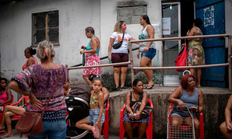People wait to get food donations distributed by an NGO at the Cidade de Deus favela in Rio de Janeiro, Brazil, on 7 April.