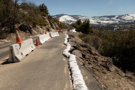 Guard rails block a road where the hillside washed away in winter storms.