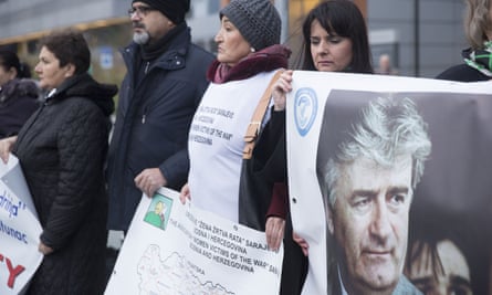 Protesters stand outside the court in The Hague with posters including one of Radovan Karadžić as they wait for the verdict on Ratko Mladic in November.