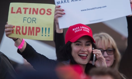 A woman hoods a sign expressing Latino support for Republican presidential candidate Donald Trump at his campaign rally in Costa Mesa, California.