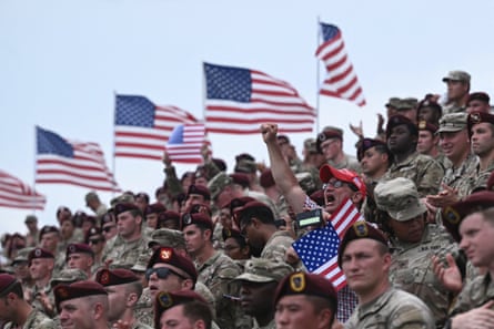 Military personnel sit in stand