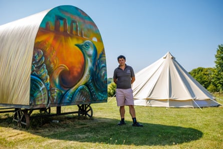 Dan King next to a bell tent and a painted wagon