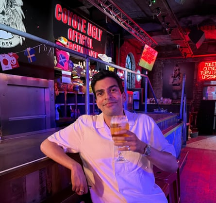 Ammar lifts a beer in an otherwise empty country-and-western-style bar