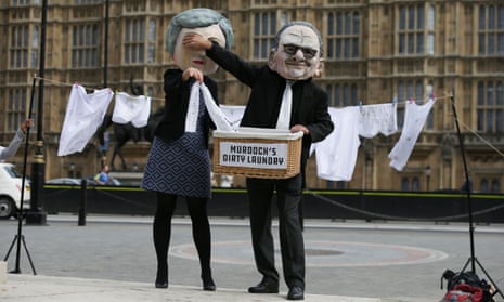 Activists from Avaaz posing as Theresa May (left) and Rupert Murdoch protest against the proposed takeover of Sky by 21st Century Fox outside Westminster
