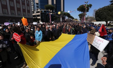 People in the streets hold Ukrainian flag and banners
