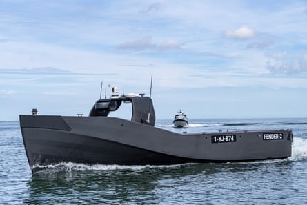 A small grey military sea craft on calm water