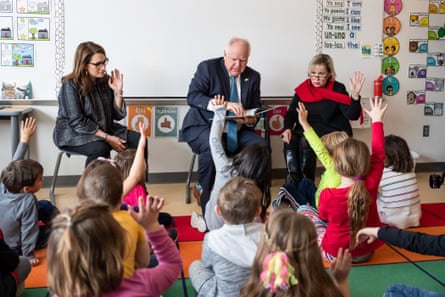 a man reads a story to children in a classroom