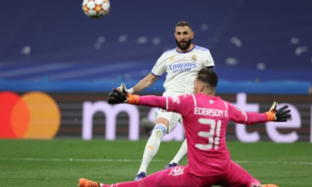 Karim Benzema dari Real Madrid melepaskan tembakan melewati Ederson dari Manchester City selama semifinal Liga Champions.