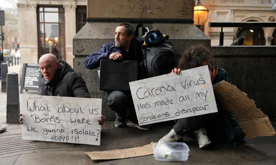 A homeless man holds a sign reading “What about us Boris - were we gunna isolate? Help!”