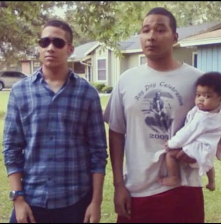 two men, with Glenne holding a baby on his hip