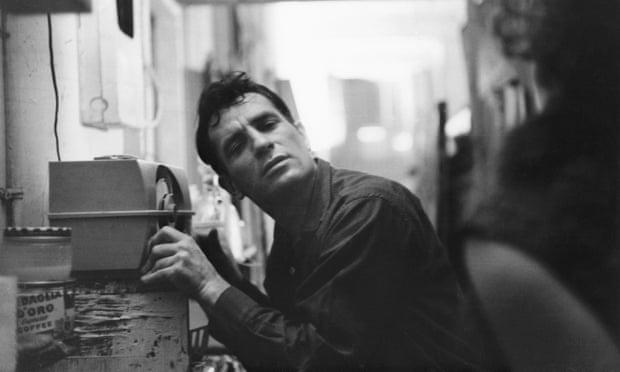 Jack Kerouac leans closer to a radio to hear himself on a broadcast, in 1959.