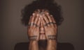 woman with tattoos on her hands covers her face with her hands