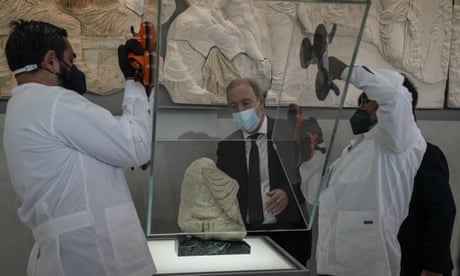 Δύο συντηρητές στο Μουσείο της Ακρόπολης αφαιρούν μια γυάλινη θήκη από ένα θραύσμα του Παρθενώνα, δανεισμένο από το Περιφερειακό Αρχαιολογικό Μουσείο Antonino Salinas του Παλέρμο,