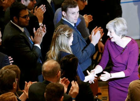 Theresa May shakes hands with delegates as she leaves the stage after giving her speech.