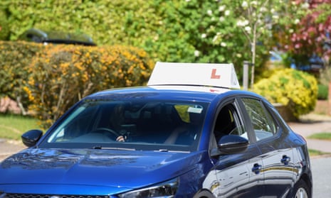 A blue car with a learner sign on top.