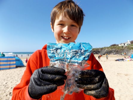 ten year old boy laurence miller holding a 1980s crisp packet he found on a beach in cornwall