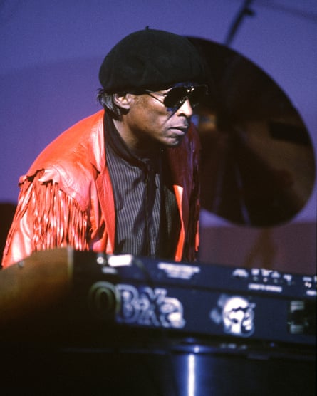 Miles Davis stands behind keyboard
