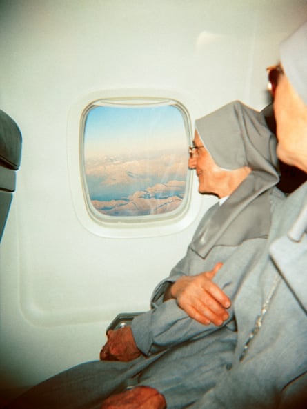 Nuns looking out the window at the Alps below on a flight from Italy to Switzerland