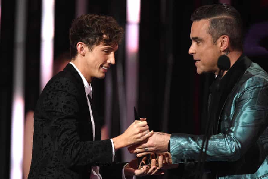 Robbie Williams presents the Aria award for best video to Troye Sivan (left).