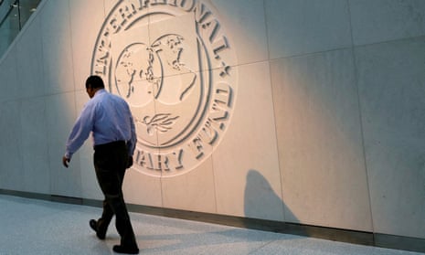Man walks past the IMF logo at HQ in Washington DC
