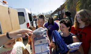 Charcoal, tarps and baby supplies are distributed outside the American Quality Lodge.