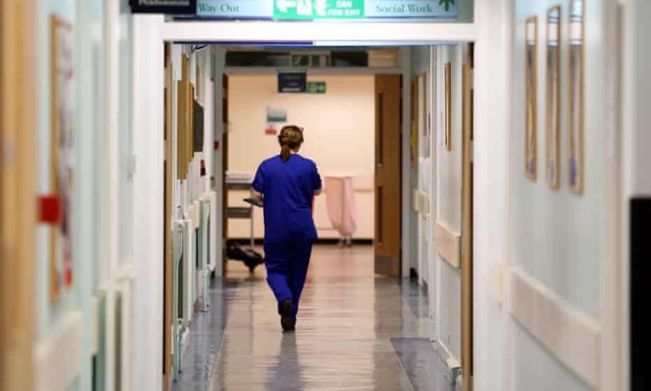 A nurse walks in a hospital corridor