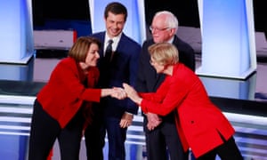 Amy Klobuchar (left) and Elizabeth Warren (right) greet each other at the beginning of the Detroit Democratic debate. Pete Butigigig and Bernie Sanders watch.