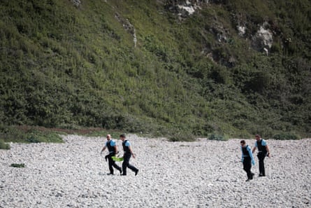 French gendarmes walk on the beach carrying a box after a search operation on the beach of Saint-Jouin-Bruneval, near Le Havre and Etretat, north-western France, on 5 July 2023. 