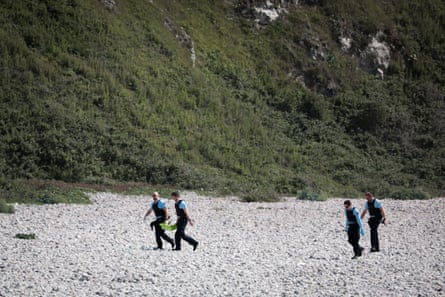 French gendarmes walk on the beach carrying a box after a search operation on the beach of Saint-Jouin-Bruneval, near Le Havre and Etretat, north-western France, on 5 July 2023.