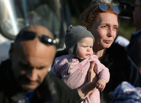A woman carries a child as civilians are moved from the Russian-controlled Kherson region of occupied Ukraine into Dzhankoi in Crimea.