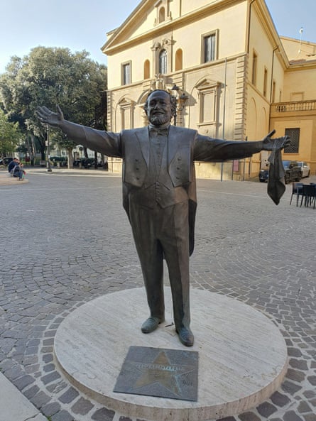 The statue before the ice rink was built, in a cobbled square.