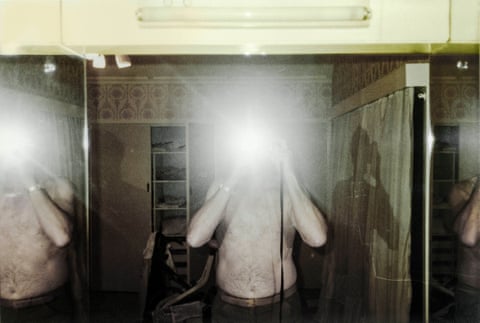 Sam Goldbloom taking a photo of himself in a mirror, with the flash obscuring his face