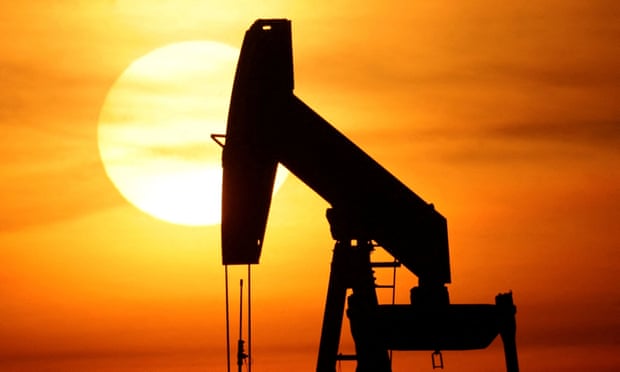 The sun sets behind an oil pump-jack