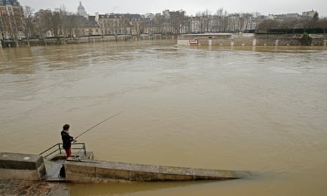 A man fishing in a flooded part of Paris