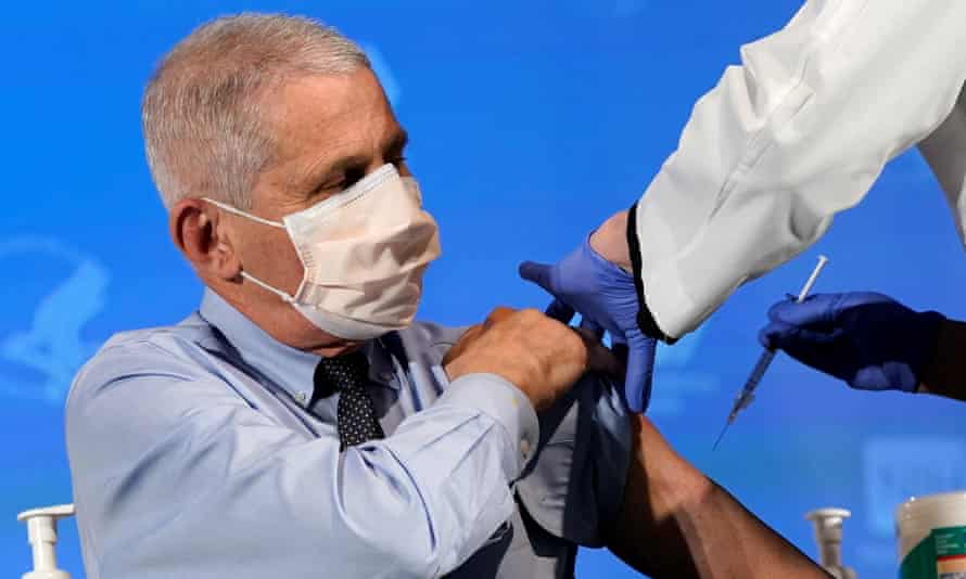 The US’s top public health official, Dr Anthony Fauci, prepares to receive a dose of the Moderna Covid vaccine