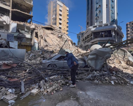 A man removes power cables in front of a building destroyed by an Israeli airstrike in Dahiyeh, Beirut’s southern suburbs, on Sunday