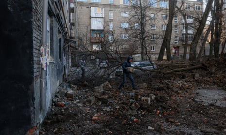Men clean their yard after rocket hit a residential building in Donetsk, Ukraine