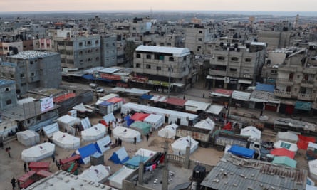 People stand outside their tents in Rafah in the southern Gaza Strip on Wednesday.
